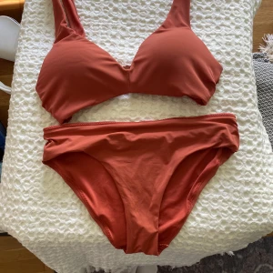 Rostfärgad bikini - Ej använd. Toppen har inlägg som ger lyft. Hör gärna av dig vid frågor eller för fler bilder. Köpare står för frakt