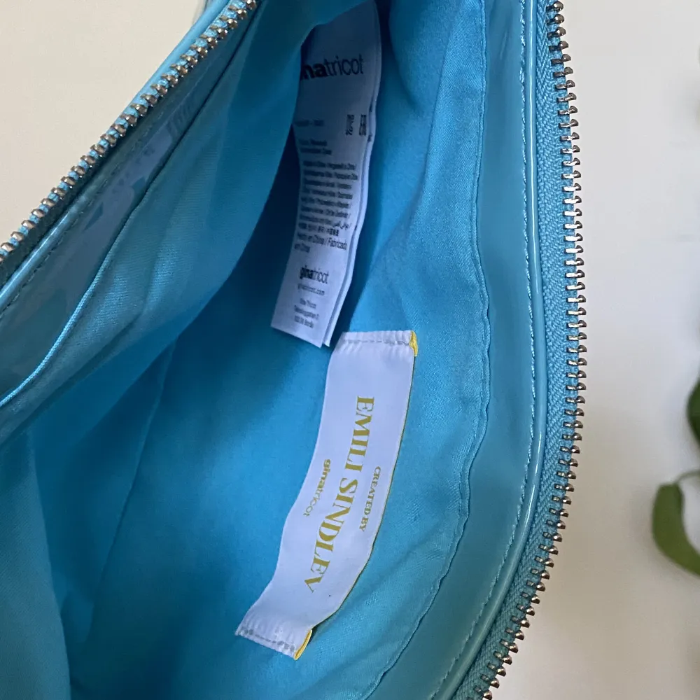 Blå handväska i lackmaterial från Gina Tricot. Använd ett fåtal gånger, men i gott skick. Mindre fläck på ena sidan som är ett fabriksfel.. Väskor.