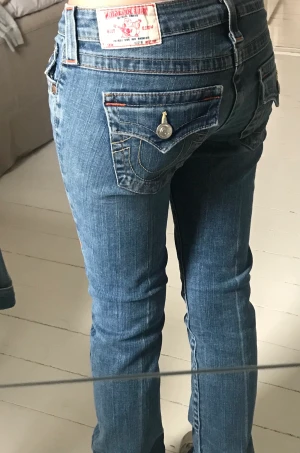 True religion jeans  - Säljer dessa trendiga lågmidjade true religion jeansen då de tyvärr har blivit för smala för mig. Det finns två pyttesmå fläckar på vänster lår som knappt märks. Midjemått: 36 Innerbenslängd: 80 Köparen betalar frakt, jag står inte för postens slarv💗