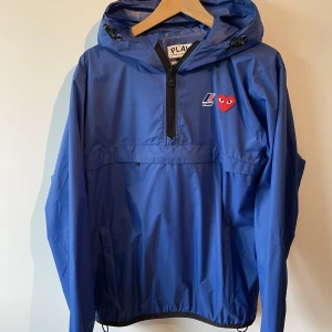 Cdg windbreaker - Säljer denna regnjacka inför hösten då jag köpt en ny. Denna jacka köptes i vintras och funkar perfekt till regnigt väder men också bara som extra lager till typ en hoodie när det inte är tillräckligt kallt för en fodrad jacka.  Köpt på nk för 1850kr.