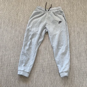 Nike tech byxor - Grå nike tech byxor i bra skick det ena snöret har gått upp skriv för närmre bild på snöret