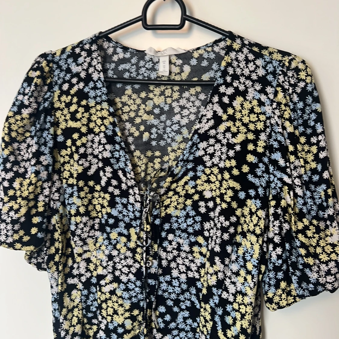 Svart topp med blommigt mönster i blått och gult i viskos - 90