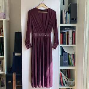 Klänning  - Vinröd klänning med drapering. Aldrig använd. Skulle säga att det passar både XS och S.