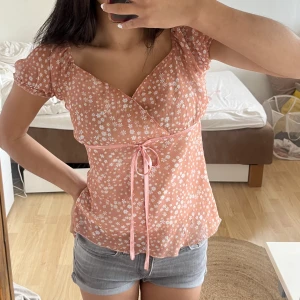 Söt blus - Jätte söt blus i rosa med små vitblåa blommor på. Den har ett snöre som man kan knyta💕 passar som som s