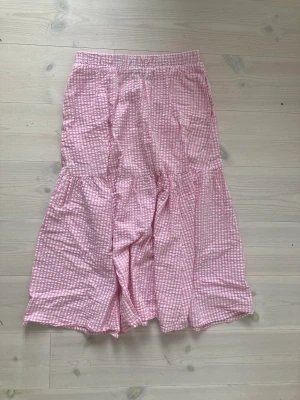 Lång kjol  - Säljer denna rutiga lång kjolen i vitt och rosa från monki. Köpt för två år sedan men knappt använd. Skriv vid intresse!😊
