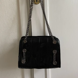 Svart axelväska från zara  - Nu säljer jag min svarta axelväska med kedjor från zara då den ej kommer till användning för mig. Endast använd fåtal gånger så är därför i mycket gott skick. 