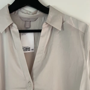 H&M skjortblus - Superfin champange/beigefärgad skjortblus i storlek S. Aldrig använd med prislapp kvar! Mitt pris 130kr  💓