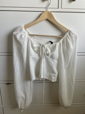 Vitt topp - En vit topp med knyte där framm. Den är fin och perfekt till sommaren. Använd vid ett tillfälle. Köpt för 250 säljer för 100. För flera frågor eller mer detaljerade bilder tveka på inte hör av dig. 