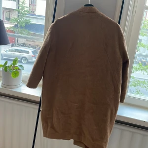 Kappa - Ljusbrun kappa. Korta ärmar. Orange innertyg. 