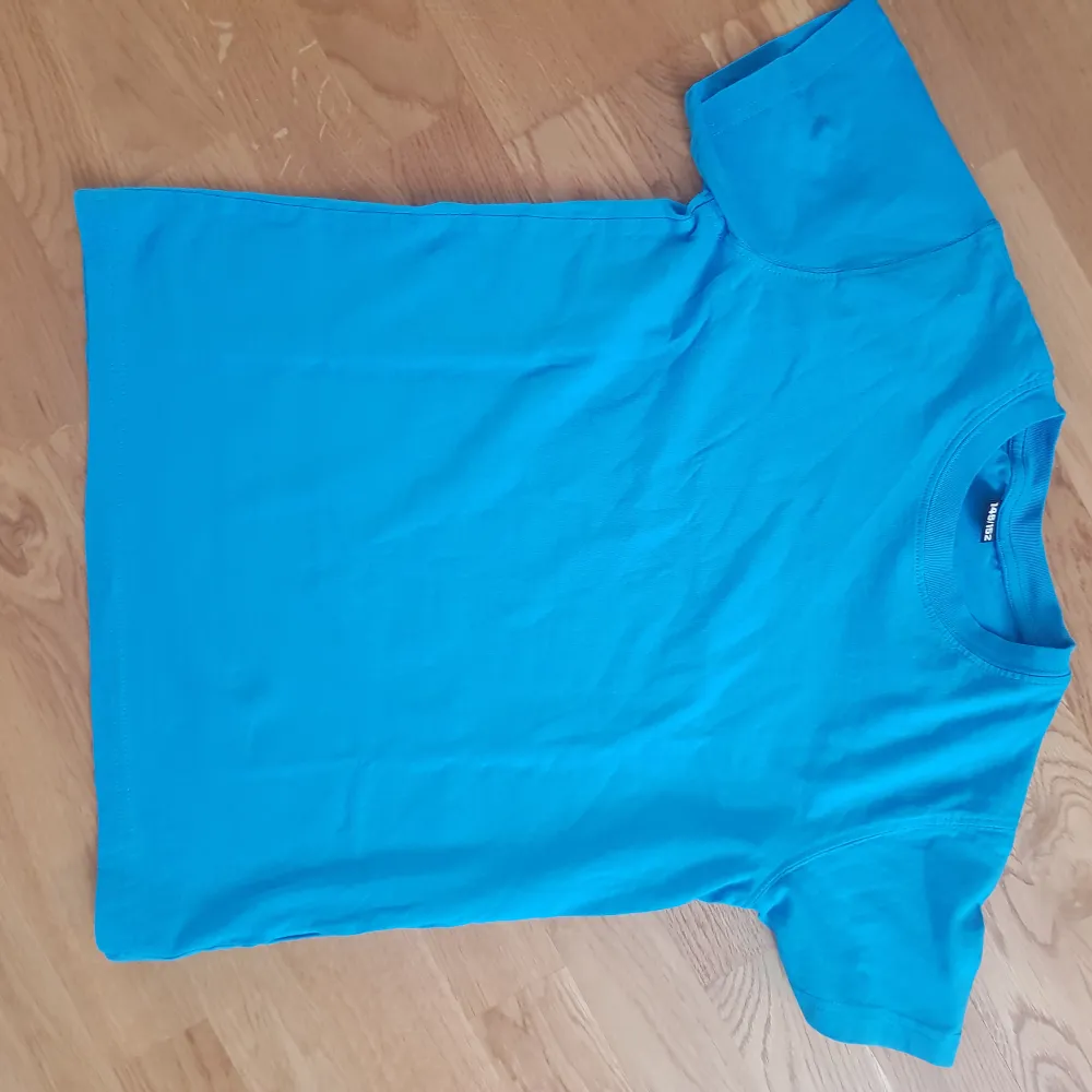 Its a blue basic t-shirt. Not used at all, its a bit tight by the neck, 100% cotten. T-shirts.