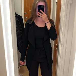 Svart Trenchcoat från BikBok - Svart trenchcoat från BikBok🖤 Säljer då den är lite för liten för mig nu💓 Fint skick men en söm har släppt pyttelite i ärmen  (syns knappt, det enda är att ärmen där inte är vikt som den andra) - därav priset🙏