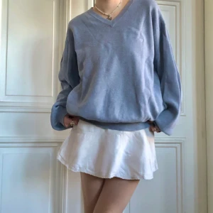 vintage ljusblå v-neck sweater  - superfin oversized vintage ljusblå stickad v-neck tröja med broderat emblem vid bröstet. skick: gott storlek: står XL men passar som L modell: s/m 169cm 