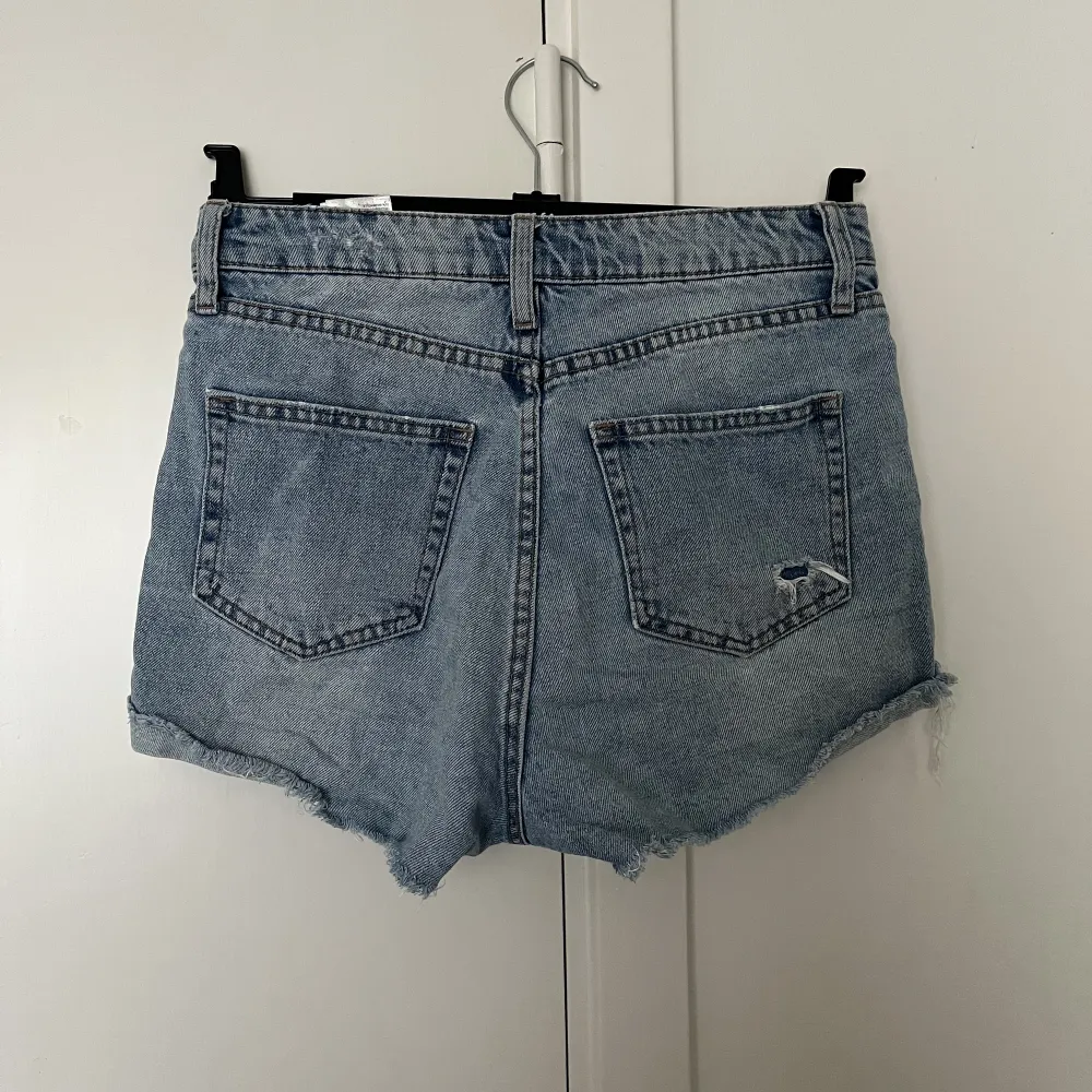 Snygga jeansshorts från H&M med slitningar och knappgylf. Säljes p.g.a för små för mig😊. Shorts.