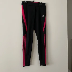 Adidas träningstights - Snygga träningstights med snörning i midjan, dragkedjan vid anklarna och liten ficka baktill. Storlek small