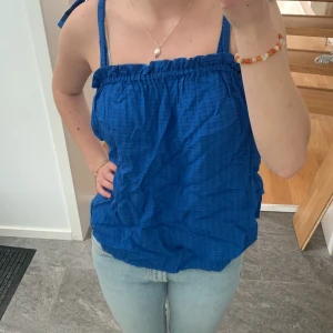 Blå topp - Jättesöt blå topp som man knyter på axlarna, som ny! Den är lite skrynklig på bilden men går såklart att stryka. Hör av er för frågor💙