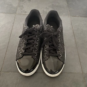 Svart glittriga sneakers  - Svart glittriga sneakers med glansig framsida, endast testade. 38/39  buda på 350+ frakt privat eller köp direkt (privat) för 400+ frakt 
