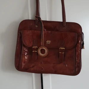 Brun väska  - Brun väska med långa remmar. 