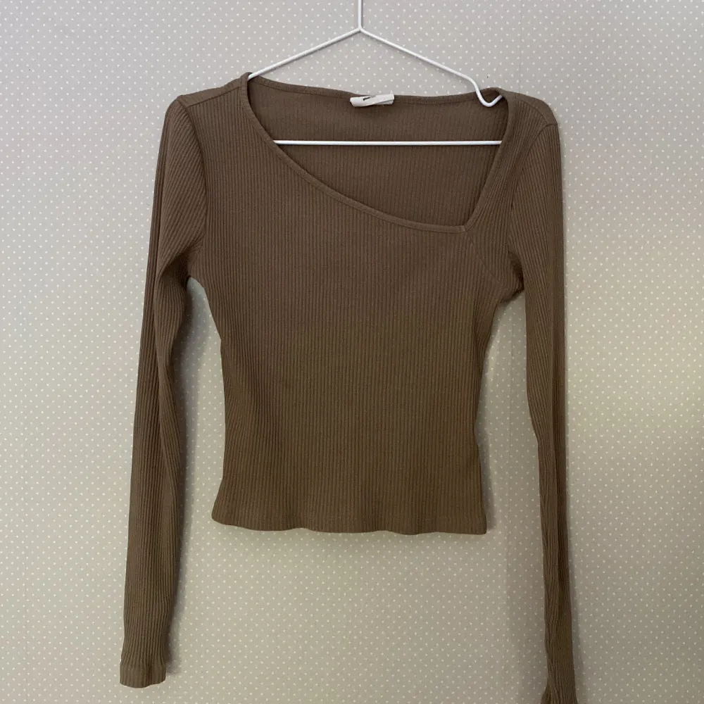 Det är en brun långärmad tröja från Ginatricot, det är en snead v-ringning . Toppar.