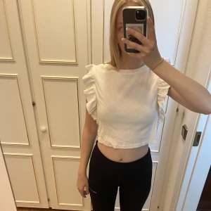 Vit t-shirt från zara - En väldigt fin och trendig topp från zara med volanger på ärmarna💗