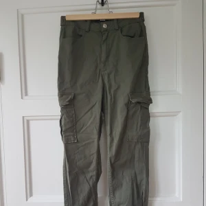 Gröna Cargo midjebyxor, strlk 38 passar S-M - Midjebyxor modell Cargo i strlk 38. Passar S-M. Dessa har alltid varit lite för små för mig så har ej använt dom.   Hör av dig om du vill att jag ska mäta något eller så! 