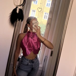 Rosa topp - oanvänd! - En rosa topp i glansigt material med en öppen rygg, helt oanvänd!