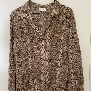 Anine Bing blus - Sååå skön Anine Bing blus med brunt ormskinnsmönster i 100% silke, perfekt till jobb/skola🫶🏼 den är i mycket fint skick och knappt använd❣️