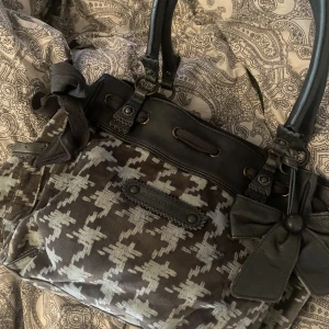 vintage JUICY COUTURE väska - En vintage daydreamer brogue houndstooth juicy väska som bara legat under en längre tid som behöver ett nytt hem. Finns två på eBay som kostar 1370,16 + 566,48 frakt och 2082,10 + ospecificerad frakt så mitt pris är mycket rimligt men de kan diskuteras 🤍