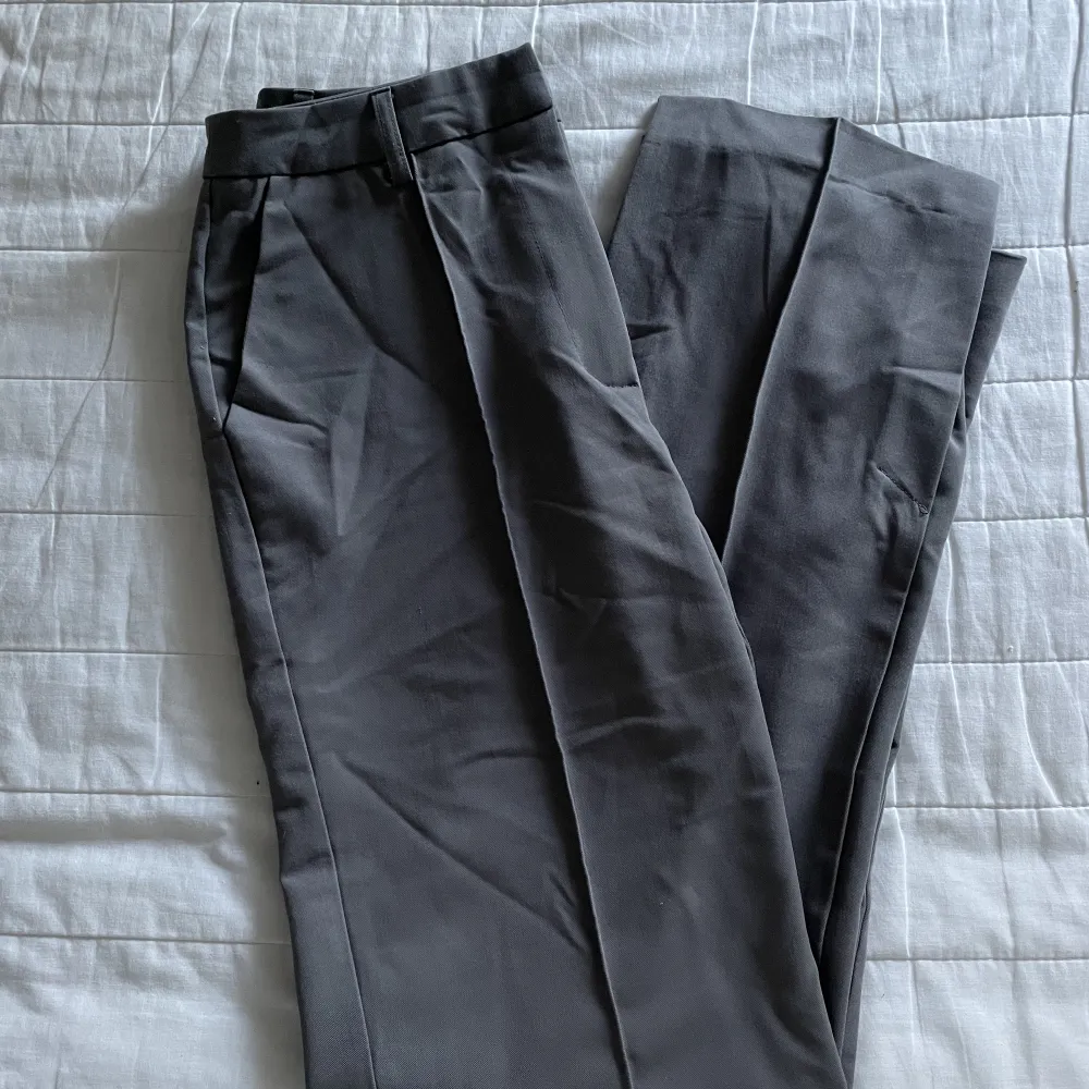 Snygga grå kostymbyxor från NA-KD, byxorna har slits både på in och utsidan vilken blir en snygg detalj . Jeans & Byxor.