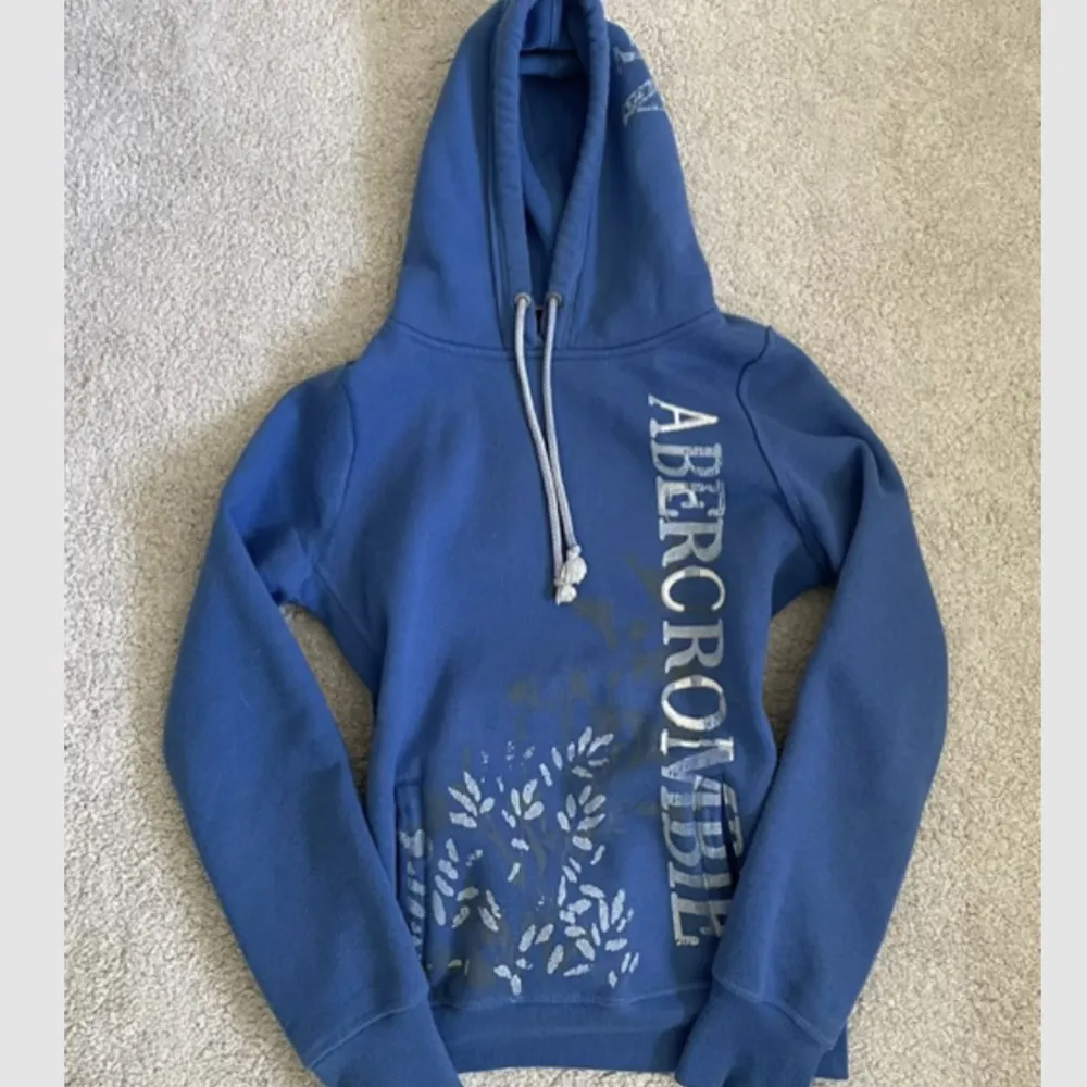 jättefin hoodie i världens finaste himmelsblå färg med så snygga tryck av blå blommor och text ✨ jättebekväm och i superskick. står M på lappen men skulle säga att den är S :) kontakta mig vid frågor 💕 kom m prisförslag. Hupparit & Collegepaidat.