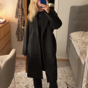 Svart lång kappa  - Svart lång kappa ifrån Vero Moda. Säljer då den är för stor. Nästan helt oanvänd. Perfekt till hösten ☺️