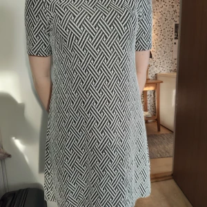 Tunika / klänning  - Välanvänd men jättefin svart -vit fiskbensmönstrad klänning / tunika H&M Divided. Ljusbrun pyttefläck på magen. Dragkedja bak. Längd 80 cm. Lite tjockare "vävt" material, väldigt fint rakt fall. 51 % bomull, 47 % polyester och 2 % elastan