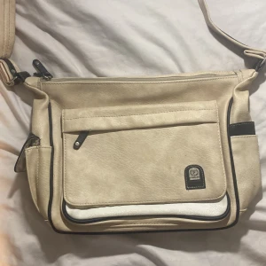 Vintage väska - Beige väska som har ett hål på insidan. Det är lätt att sy men den var så när jag fick den. Syns inte på utsidan. Har massor med fack.