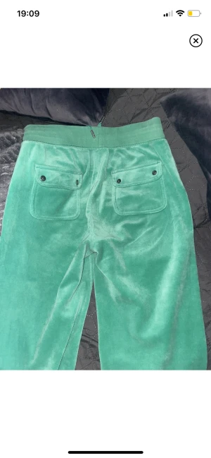 Juicy byxor - Säljer nu mina älskade gröna mjukisbyxor från, juicy couture! Det har fastnat lite nagel lim på ena benet och sömmen vid rumpan har gått upp pyttelite, Därav priset💕