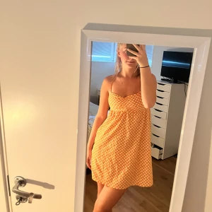Orangeblommig sommarklänning - Säljer denna orangeblommiga sommarklänningen för att den är för kort! Den är inte så väldigt använd! Har för mig att den är från H&M! Hör av er vid intresse💞💞