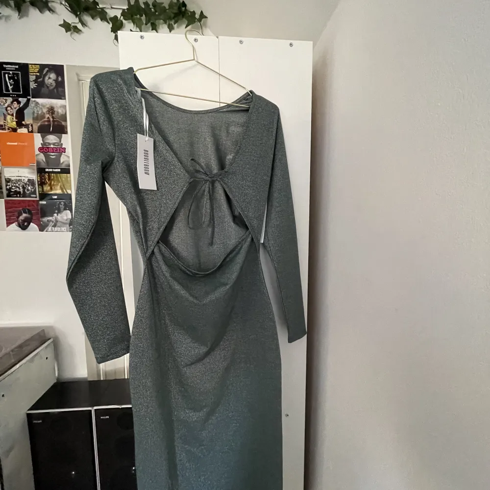Säljer denna glittriga gröna klänningen med öppen rygg då den är för stor på mig. Aldrig använd , lappen är kvar. Klänningar.