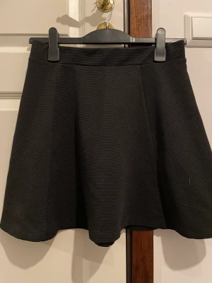 A-line skirt - Svart a-line kjol med dragkedja samt randig textur på tyget! Ca 4 år gammal!