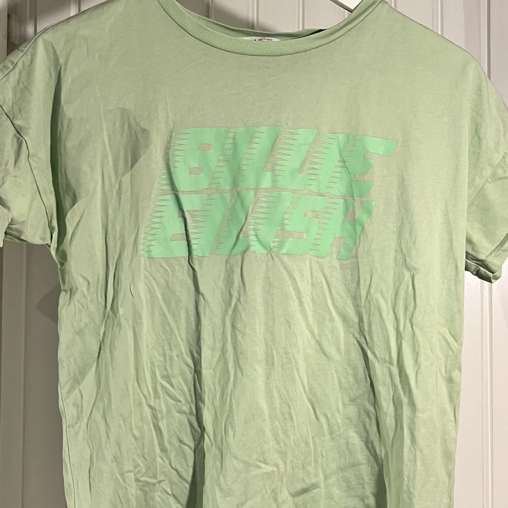 två t-shirts från h&ms barnavdelning, båda storlek 170. den svarta har blohsh på framsidan och ”billie eilish” på baksidan. den gröna har bara texten på framsidan. en av dem för 10kr eller båda för 15kr :) frakt 1st:18kr 2st:36kr eller använd köp nu!. T-shirts.