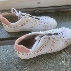 Sneakers/skor  - Ett par valentino liknade sneakers i skinn med både guld och rosa nitar och detaljer som är sparsamt använda. 