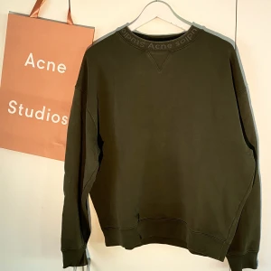 Acne Studios Neck Logo Sweater Grön - Hej! Säljer en riktigt snygg Acne Studios Neck Logo sweatshirt i mörkgrön färg. Mycket bra skick. Storlek Medium men passar även Large. Nypris på över 3000kr. Påse medkommer. Priset är inte hugget i sten. Hör av dig vid frågor. 