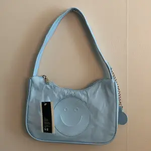 Ljusblå smiley väska från H&M 