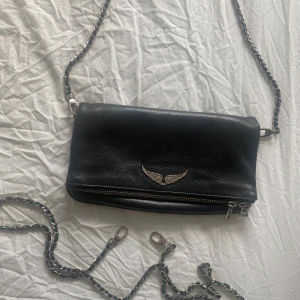 Zadig Voltaire väska - Zadig Voltaire väska i modellen ROCK💕💕 Väskan är i relativt bra skick, den korta kedjan är dock lite ”rostig”. Men den långa kedjan (som går att göra kort) är knapp använd, och därmed inget rostig!