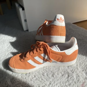 Addidas gazelle - Billiga!!! Orangea/peach addidas gazelle skor. I nyskick, har bara använts ett par gånger. Säljer dem för hälften av priset som jag köpte dem för! Är beredd att diskutera priset!