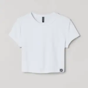 Fin vit croppad t-shirt i coolt material från H&M. Inga fläckar och syns knappt att den är använd. Säljs för att den inte används längre. Köpt för 99kr och säljer för 25kr.