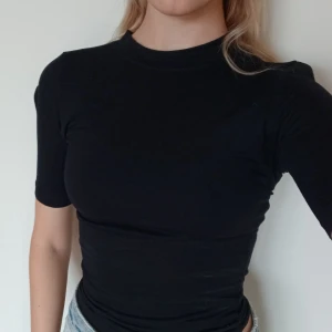 Basic black t-shirt  - Snygg formpassande svart t-shirt med liten krage. Påminner om skims. Perfekt skick. Storlek 34 (XS)