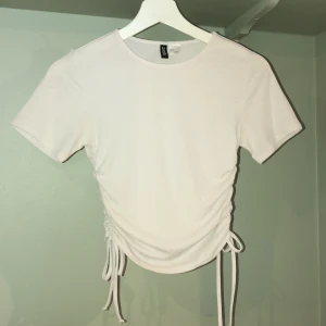 Vit topp med dragsko - Superfin tshirttopp med dragsko, endast använt väldigt få gånger