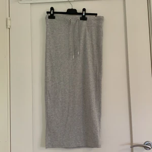 Grå kjol  - Grå kjol ifrån Gina tricot med snörning i midi längd 