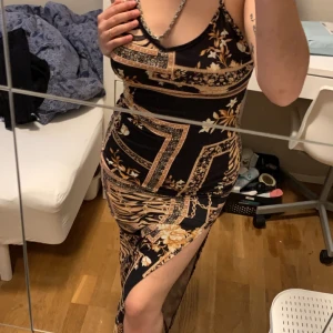 Lång klänninh - Klänningen är lång, har skönt material, är i bra skick. Den har en liten öppning vid benet, korsar i ryggen. Den är i stl S men passar som M