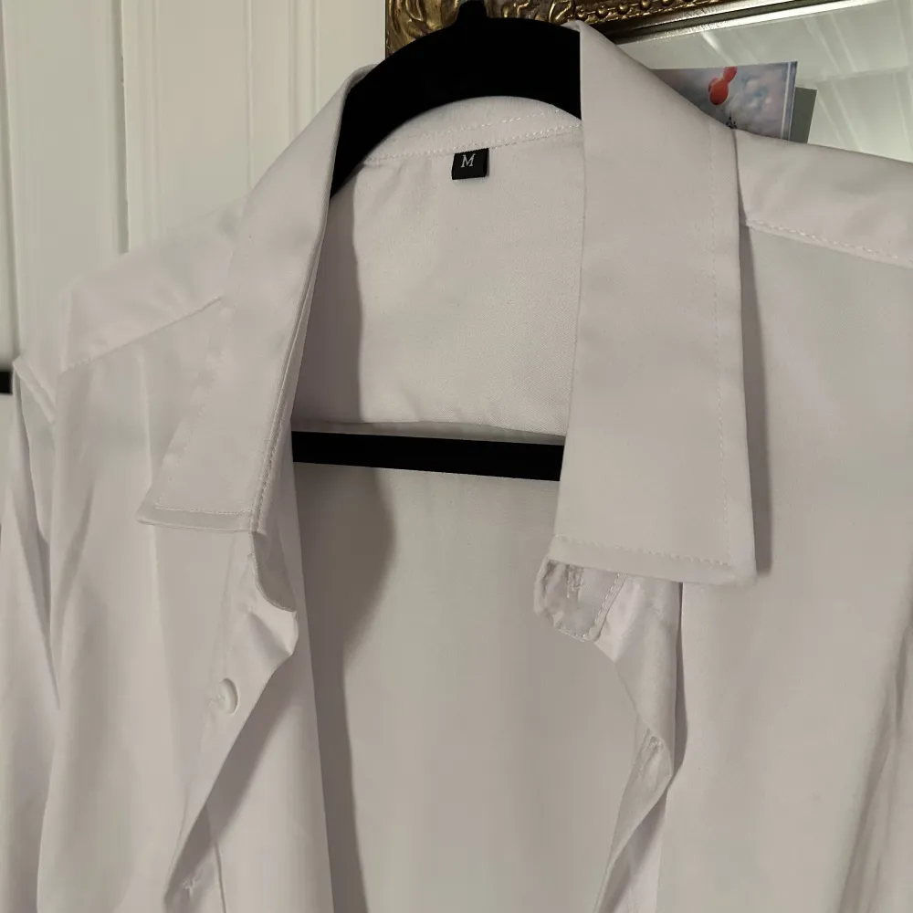 En vit simpel skjorta, storlek M . Blusar.