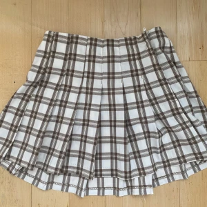 Kjol plisserad strl 34 brun vit nytt skick - Säljer denna vackra plisserade (plaid) kjolen från h&m pga att jag köpte fel storlek☘️ Köpte för 199 kr men säljer för 125 kr. Fri frakt och priset kan diskuteras vid snabba köp!💕 