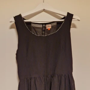 Svart klänning  - Svart klänning med glitter i urringningen. Den är från ONLY i storlek 40. Endast testad.